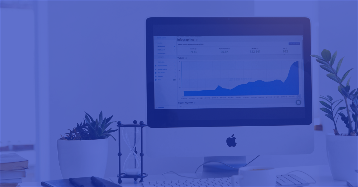 An Apple iMac desktop computer displaying a data analytics dashboard with an upward-trending growth chart.